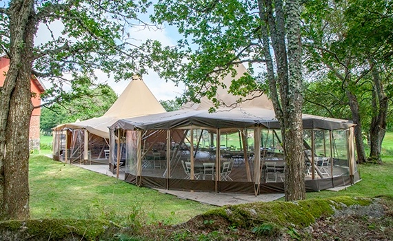 Enkelt bryllup på gårdsplass med to telt med vegger for le i grønne og naturlige omgivelser. Vi leverer telt, lavvo, bar, møbler, dekor og utstyr for servering